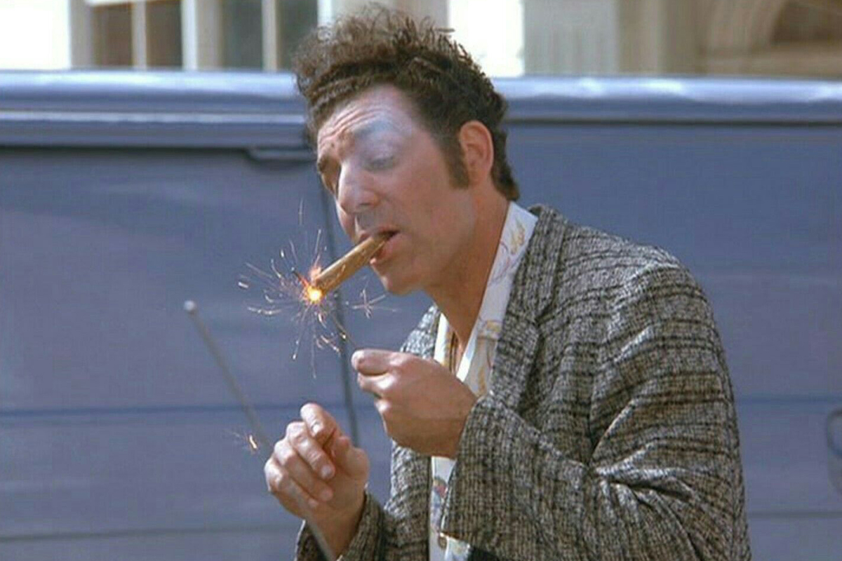 Kramer from Seinfeld lighting a cigar with sparks as he enjoys the moment