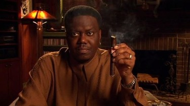 Bernie Mac holding a cigar, exuding confidence and charisma