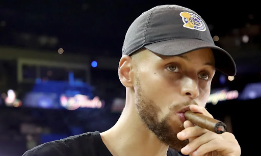 Steph Curry casually smoking a cigar at an event